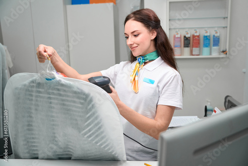 Woman washhouse worker scanning tag on clothes photo