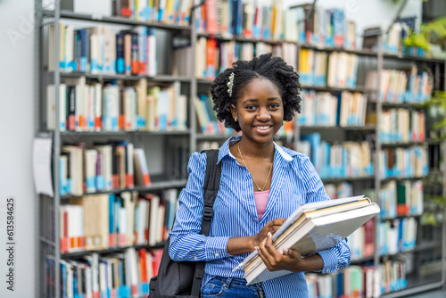 Portrait of black female student standing in a library
