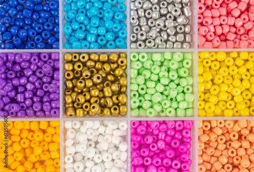 Plastic beads of different colors in separate cells of the container