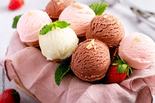 Cones with chocolate, vanilla and strawberry taste in wooden box on light gray table