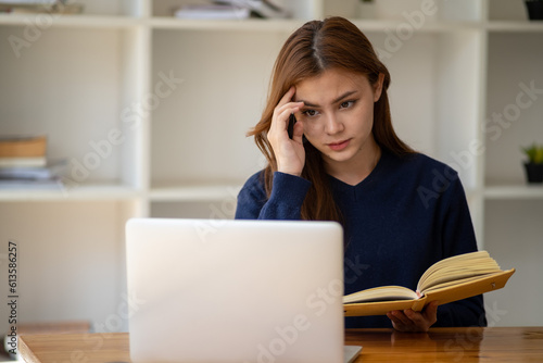 Stress, student with laptop at home frustrated agry unhappy young woman looking at laptop screen book, Exhausted female student studying online with computer photo