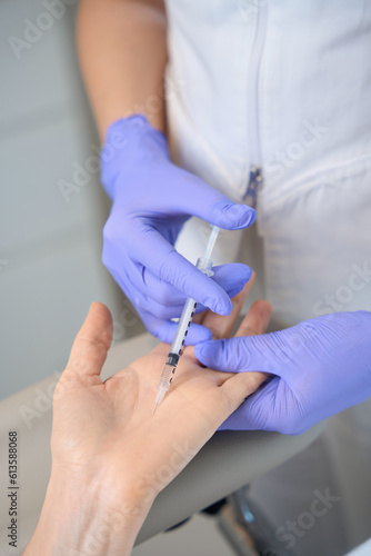 Closeup of doctor hands in gloves making palm injection