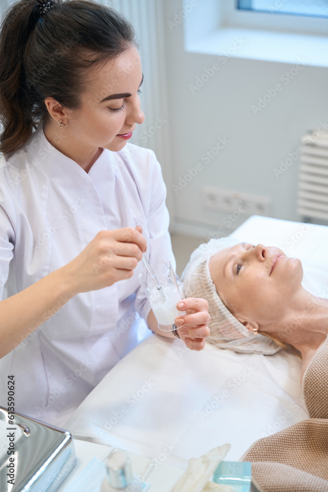 Obraz premium Female beautician preparing for beauty procedure in cosmetologist office