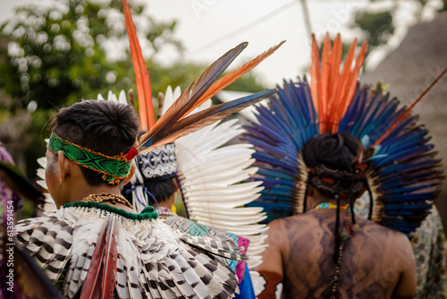 Sao Paulo, SP, Brazil - April 20 2023: Indigenous people from a village in the Brazilian Amazon wearing colorful feather headdresses details.