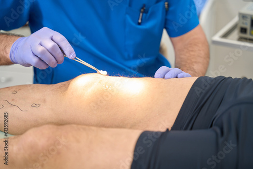 Doctor who disinfects skin on patient leg