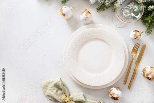 Canvas Print Beautiful Christmas festive table setting with white plate, golden balls on white