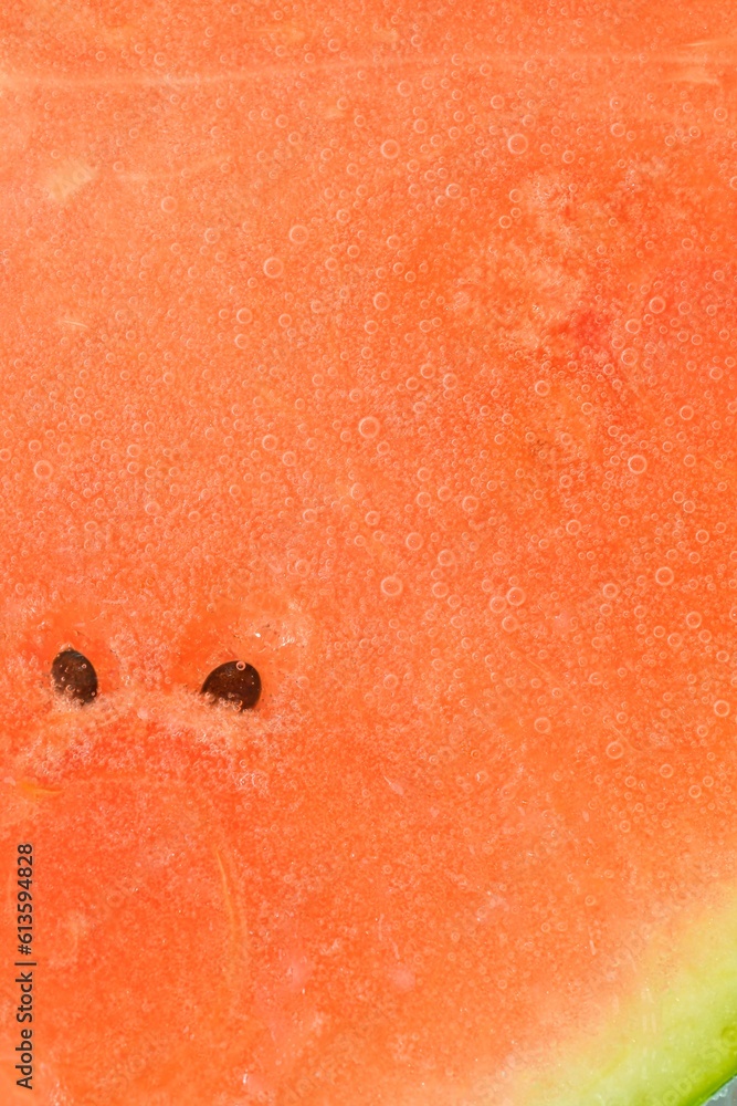 Close-up of juicy watermelon slice. Slice of ripe melon in sparkling water, close-up. Vertical macro image.