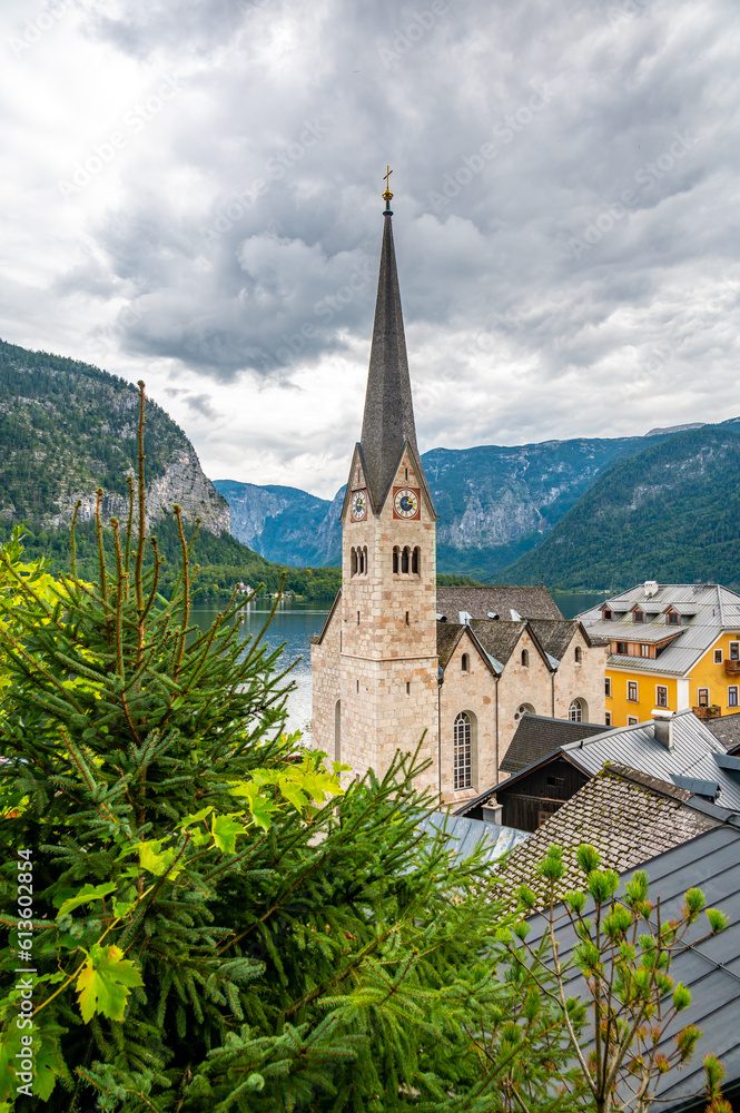 Famous Hallstatt city panorama with typical church near the Hallstatter see. Dramatic clouds on the sky. Famous tourist destination in Austria.