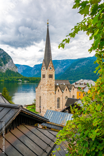 Famous Hallstatt city panorama with typical church near the Hallstatter see. Dramatic clouds on the sky. Famous tourist destination in Austria. © Martin