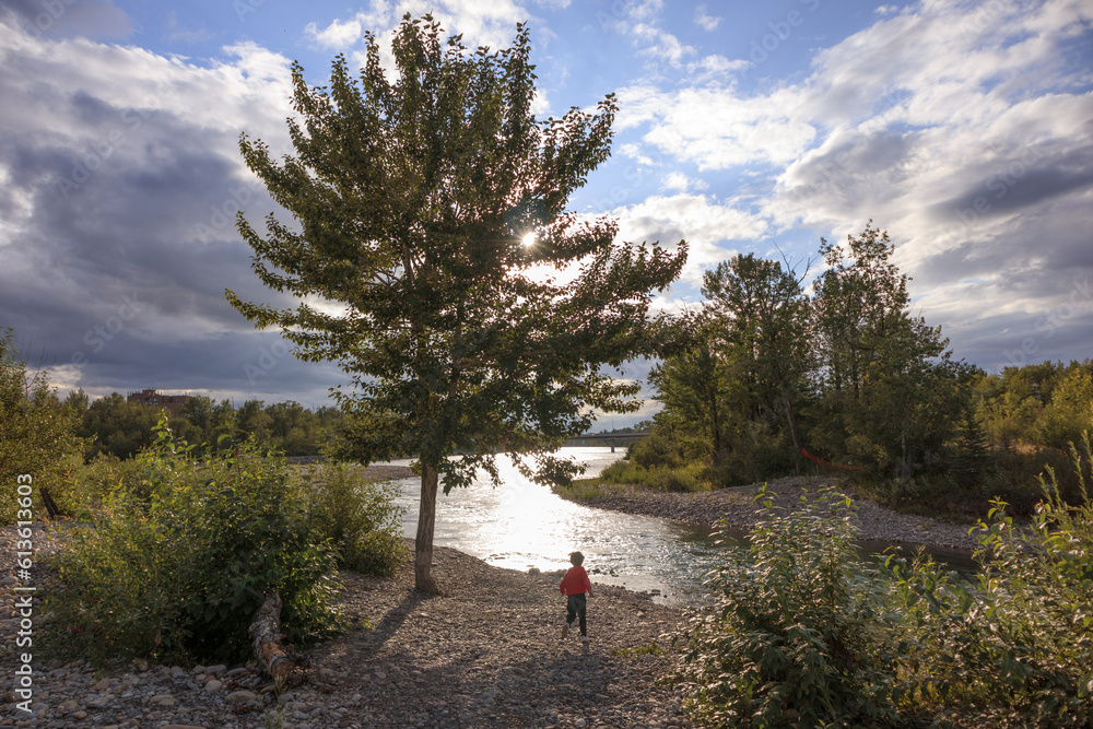 Young boy running to the river in a park on a sunny day Young boy running to the river in a park on a sunny day
