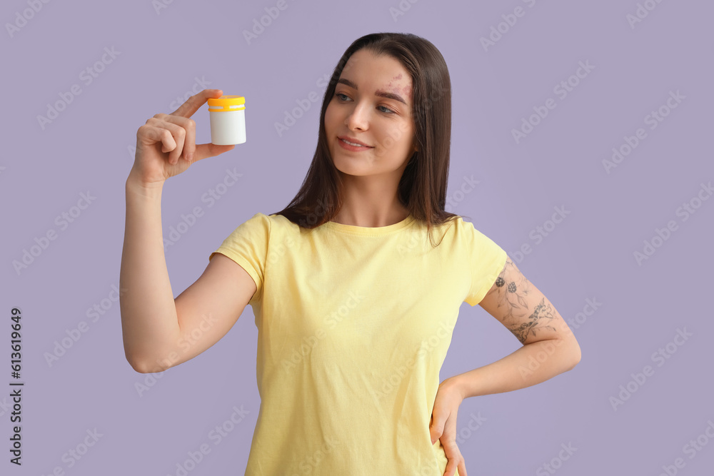 Young woman with bottle of vitamin supplements on lilac background Young woman with bottle of vitamin supplements on lilac background