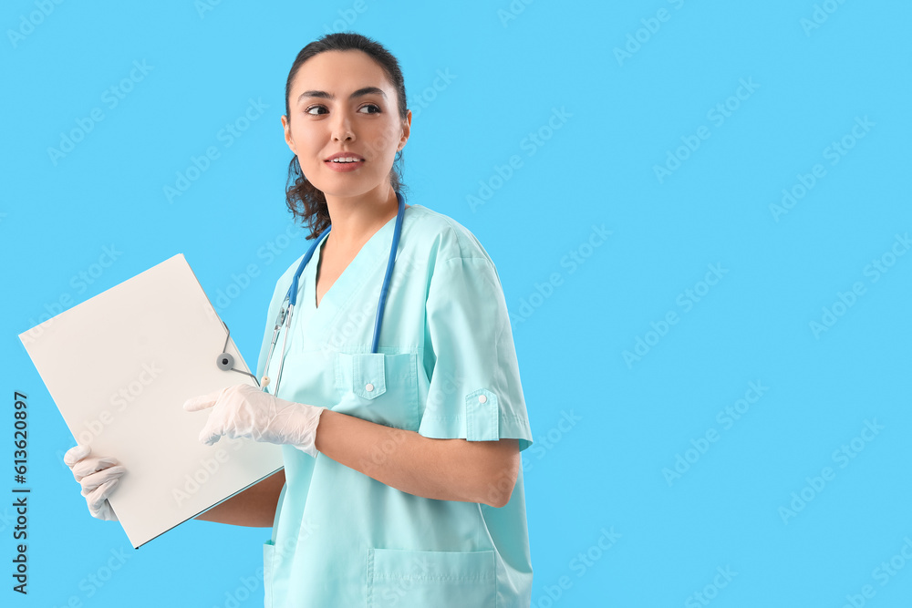Female medical assistant with folder on light blue background Female medical assistant with folder on light blue background