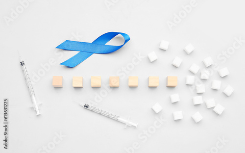 Word INSULIN with awareness ribbon, syringes and sugar cubes on white background