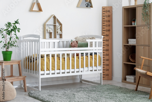 Interior of children's bedroom with crib, shelves and toys