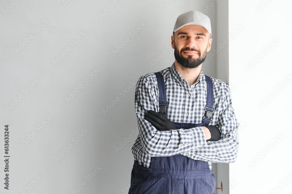 Laughing construction worker on the background of a gray concrete wall. Renovation. place for text Laughing construction worker on the background of a gray concrete wall. Renovation. place for text