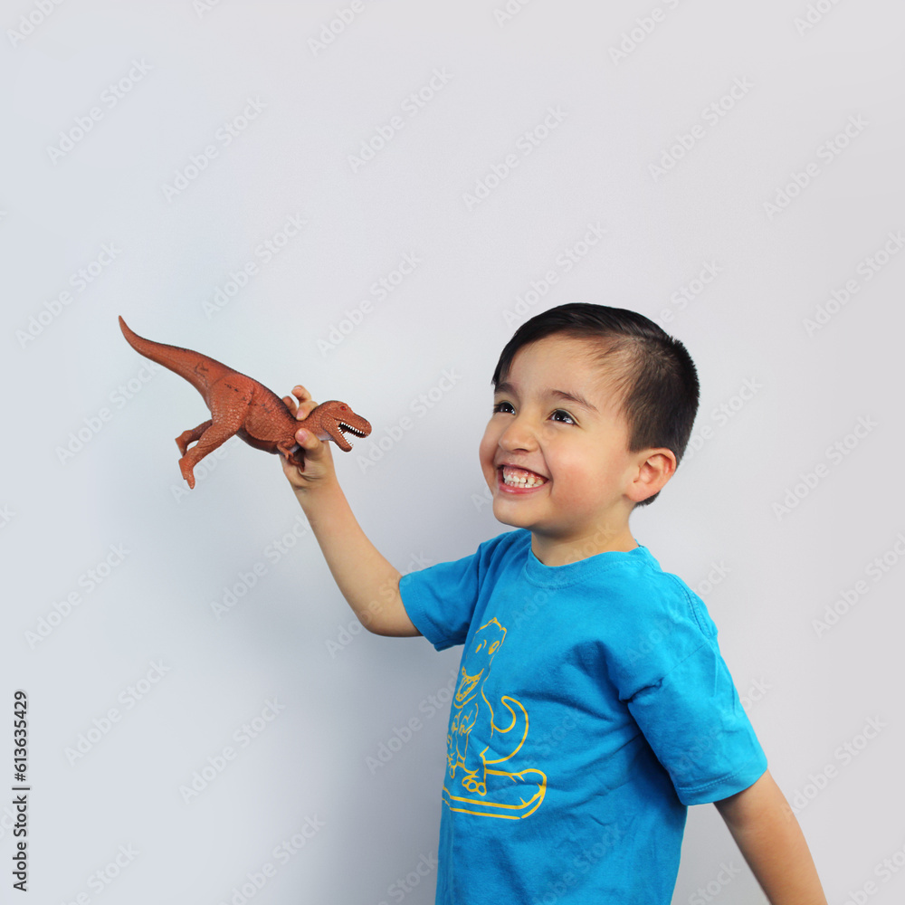 child playing, holding a dinosaur toy, body three-quarter view, big ...