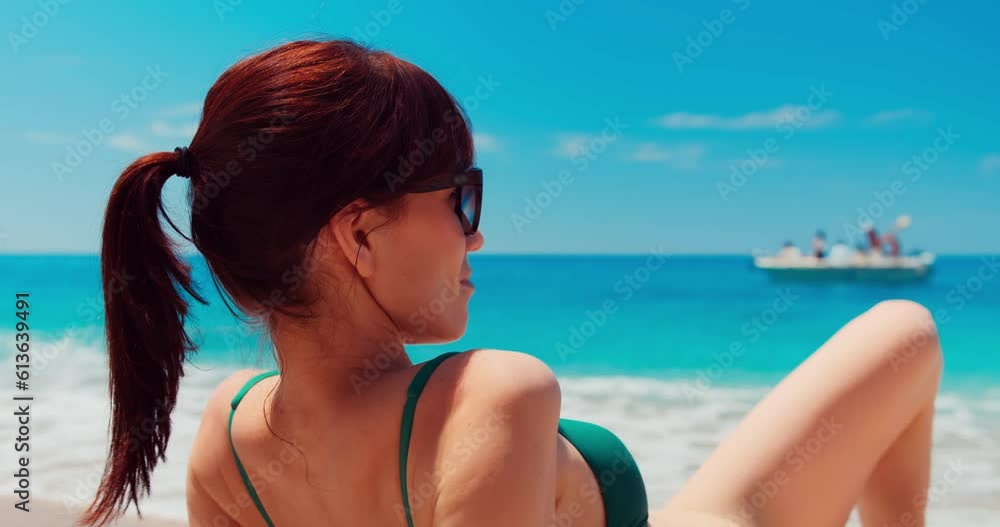 Woman on beautiful sea beach. Back view of a woman sitting on the beach Woman on beautiful sea beach. Back view of a woman sitting on the beach