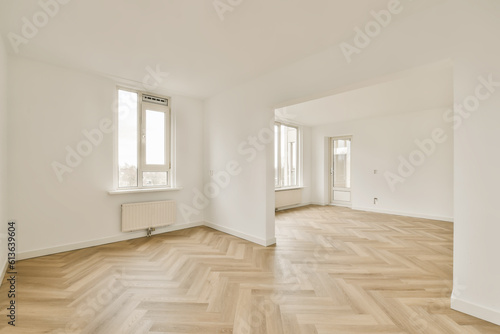 an empty room with wood floors and white walls  there is a large window in the wall to the right