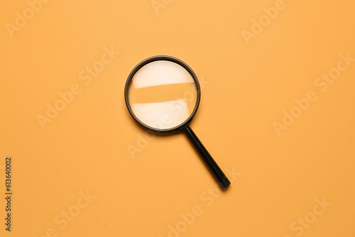 Black magnifier on orange background