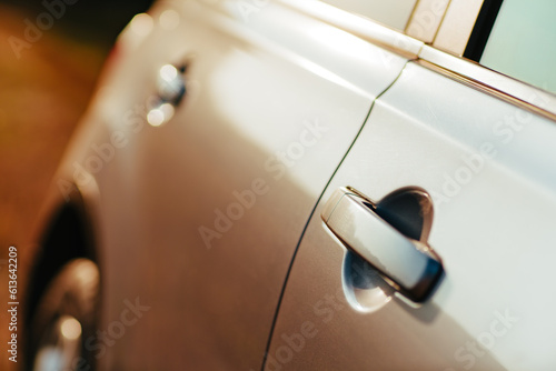 Close-up of the silver car door at sunset light