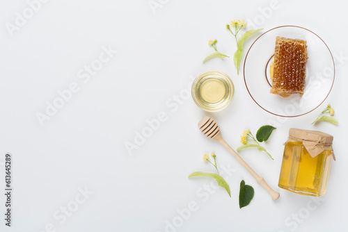 Linden honey with leaves and flowers on color backgroung, top view