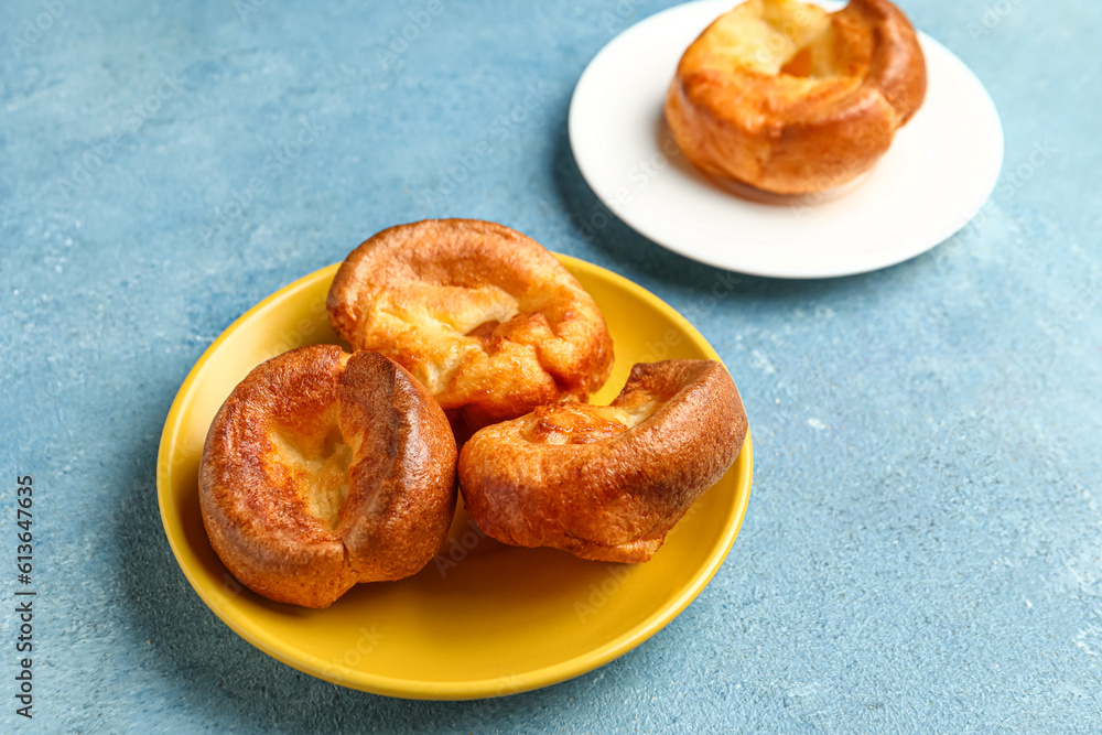 Plate with tasty Yorkshire pudding on blue background Plate with tasty Yorkshire pudding on blue background