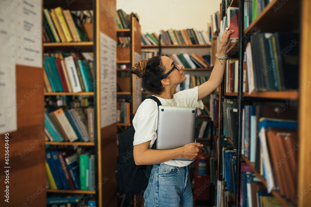 A student stuying and reading books in a public library. A student stuying and reading books in a public library.