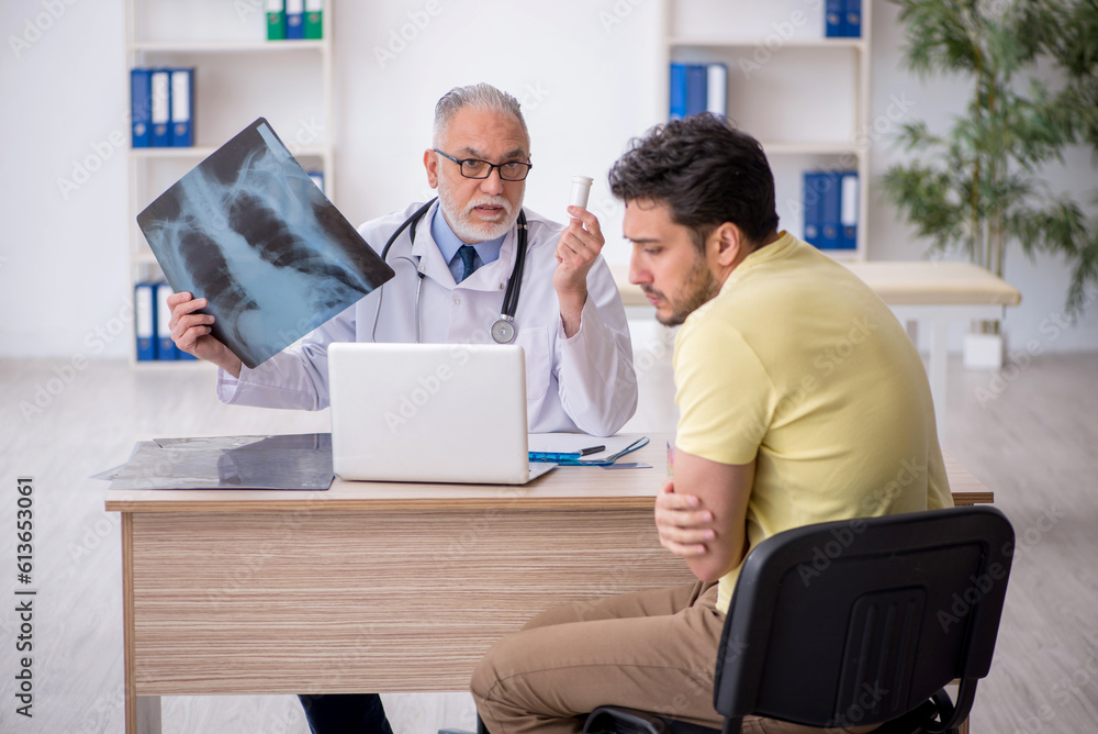 Young male patient visiting old male doctor radiologist Young male patient visiting old male doctor radiologist