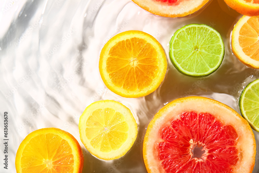 Different citrus fruit slices in water on white background Different citrus fruit slices in water on white background