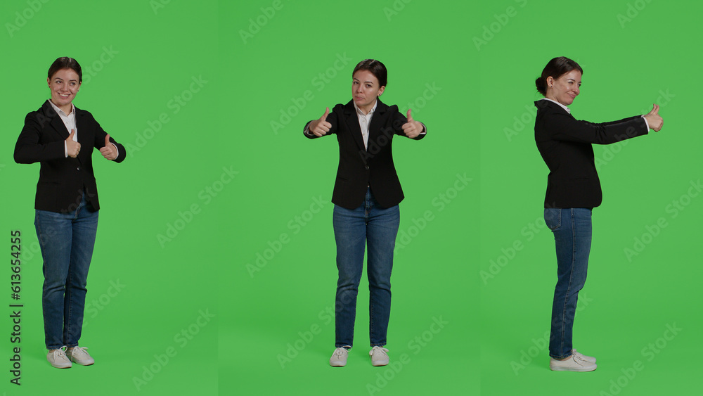 Businesswoman giving thumbs up over green screen studio backdrop, expressing like and approval on camera. Office worker in suit doing okay agreement gesture, acting positive and cheerful. Businesswoman giving thumbs up over green screen studio backdrop, expressing like and approval on camera. Office worker in suit doing okay agreement gesture, acting positive and cheerful.