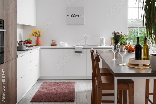 Interior of light kitchen with stylish island table © Pixel-Shot