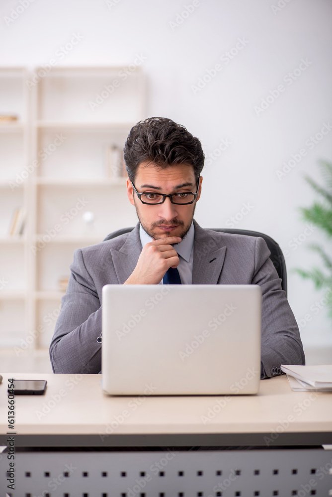 Young male employee and too much work in the office Young male employee and too much work in the office