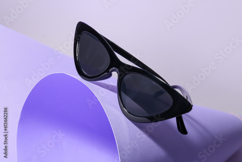 Stylish sunglasses on lilac background