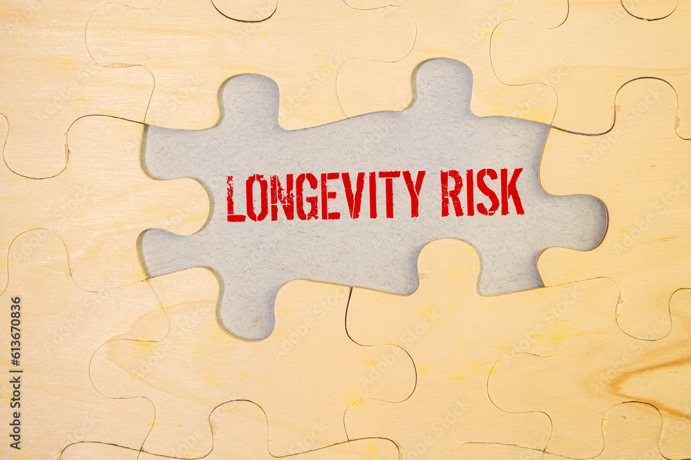 A note with the inscription Longevity risk and a pen. Long-term risk. Pension fund. Insurance companies. A note with the inscription Longevity risk and a pen. Long-term risk. Pension fund. Insurance companies.
