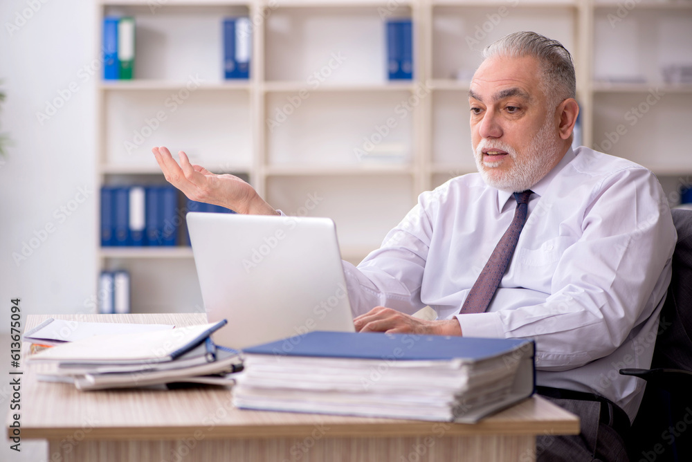 Old male employee working in the office Old male employee working in the office