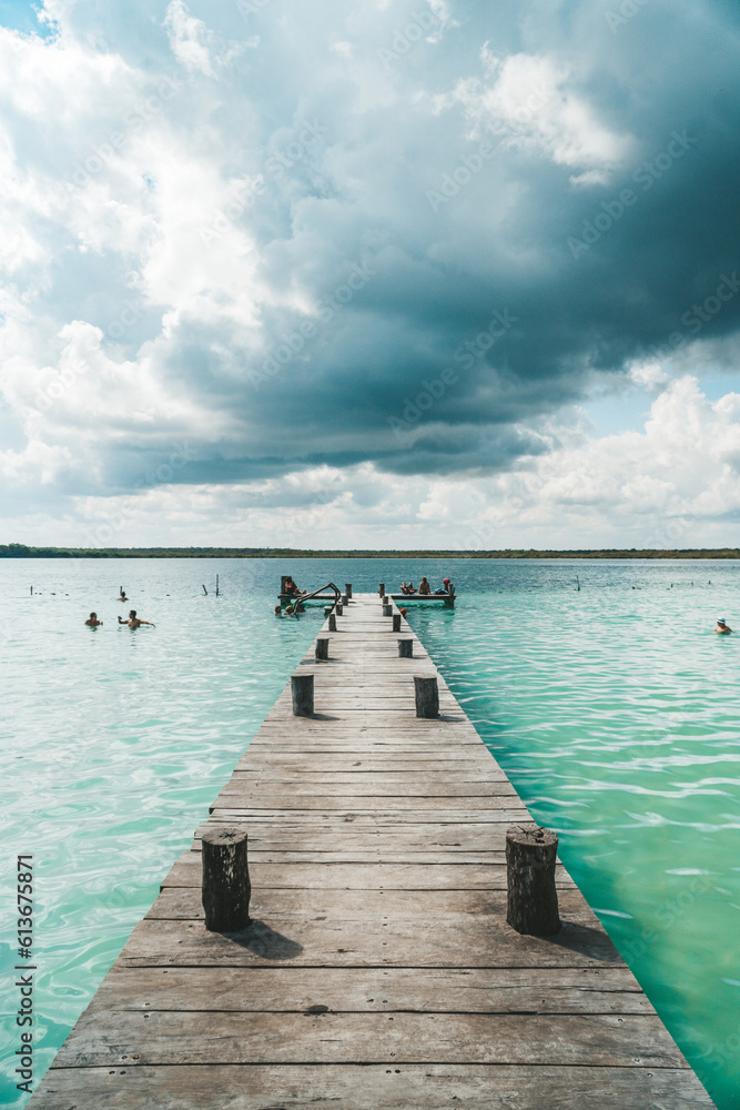 Obraz premium Wide shot showing pier leading to a fresh water blue lagoon in Bacalar, Mexico.