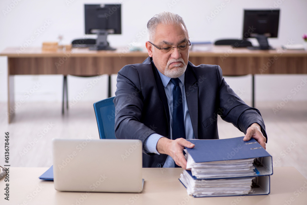 Old male employee working in the office Old male employee working in the office