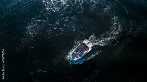 Aerial top view of a wake boat navigating the open river 