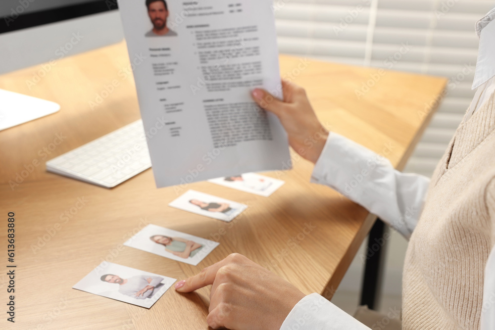 Human resources manager reading applicant's resume in office, closeup Human resources manager reading applicant's resume in office, closeup