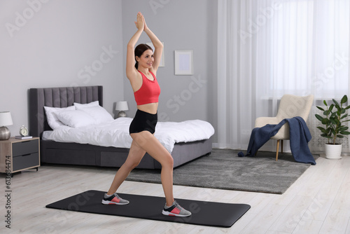 Happy woman doing morning exercise at home