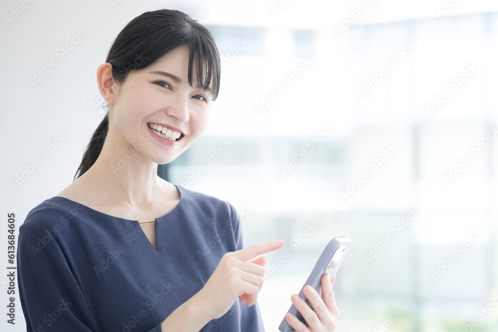 スマホをもって笑顔な美しい人　カメラ目線　見つけるや検索のイメージ