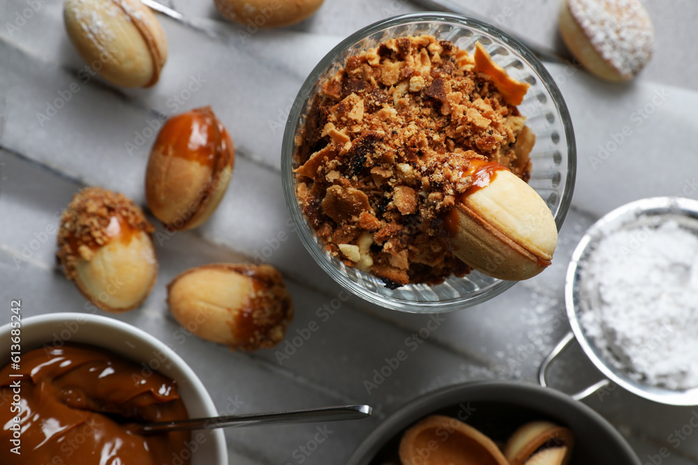 Delicious walnut shaped cookies with condensed milk on grey table, flat lay Delicious walnut shaped cookies with condensed milk on grey table, flat lay