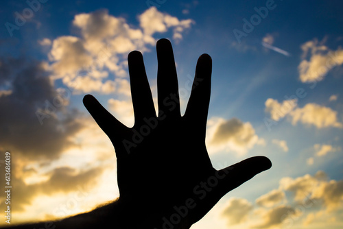 silhouette five fingers with sky