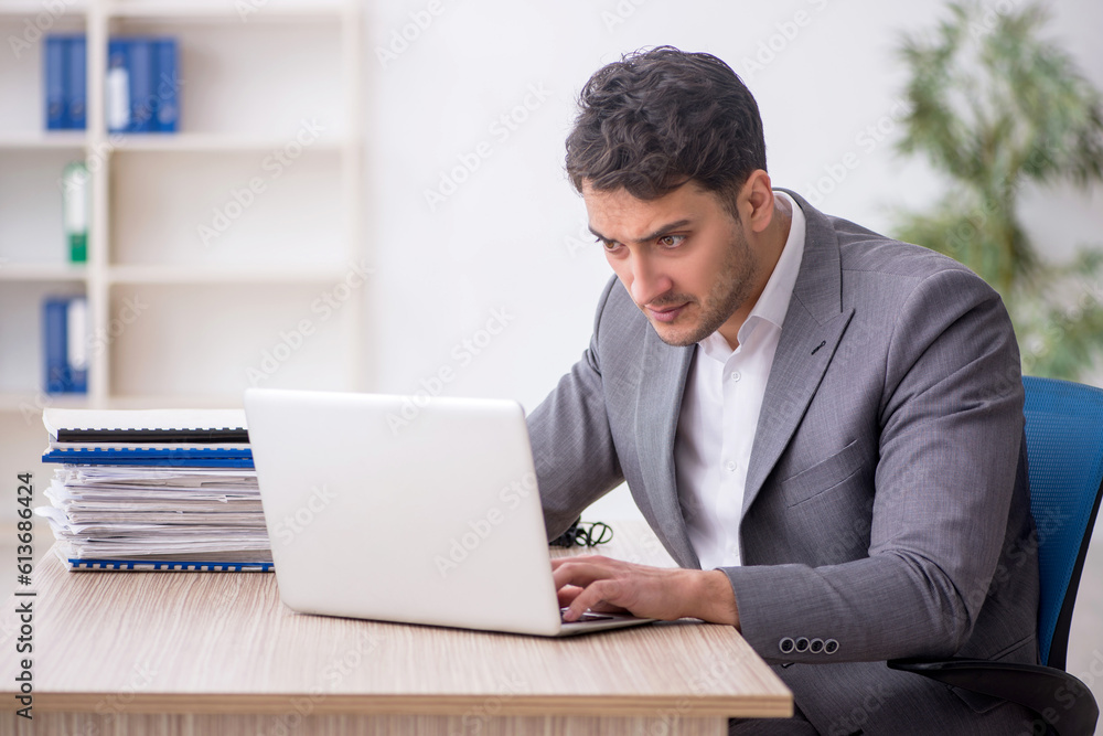 Fototapeta premium Young male employee and too much work in the office