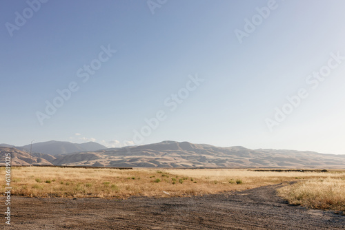 Sunny summer landscape in California. Scenic landscape with mountains, yellow grass in the foreground, clear sky on a sunny day.