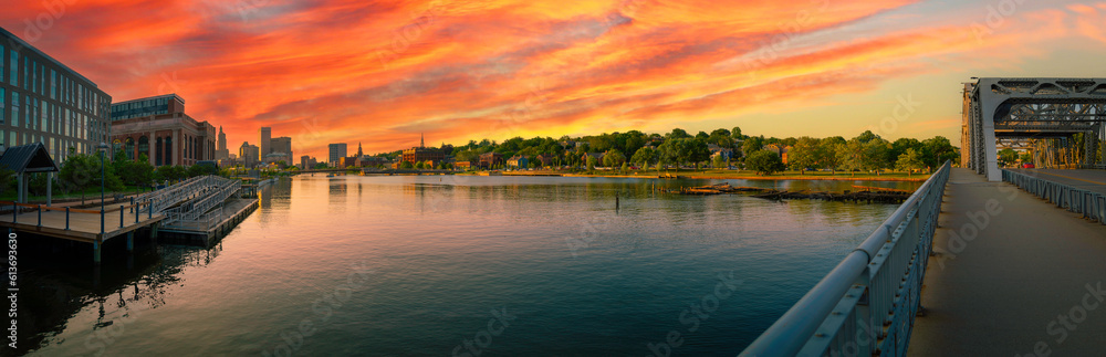 Sunset panorama over Providence River in Rhode Island. Metropolitan City skyline, riverwalk park,  and old highway bridge.