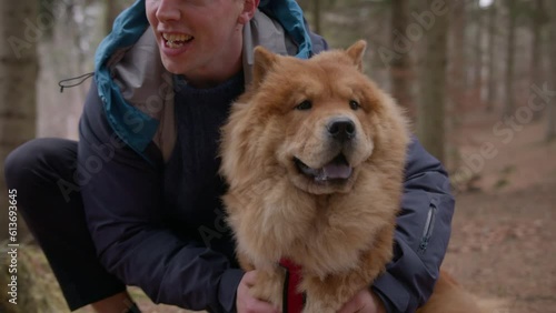 A Man Pets His Furry Chow Chow Dog