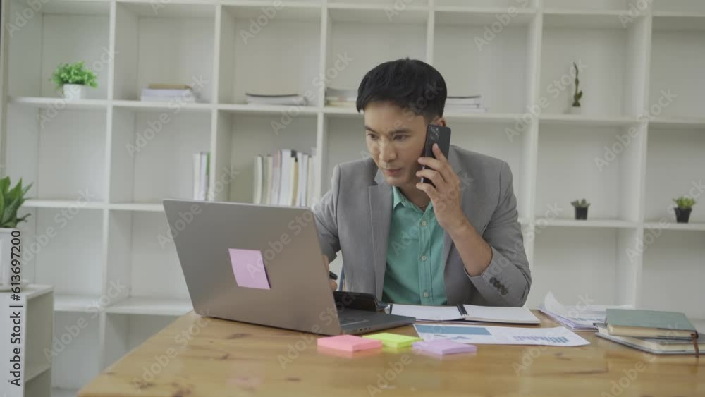 Businessman working in office at desk with financial graph document and laptop Freelance manager holding smartphone using chat messenger app. Career VIDEO 4k Businessman working in office at desk with financial graph document and laptop Freelance manager holding smartphone using chat messenger app. Career VIDEO 4k