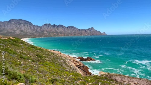 Koeel Bay Dappat Se Gat cinematic windy surf waves crashing stunning Kogel Bay Beach Cape Town South Africa coastline aqua deep blue water Gordon's Bay  Garden Route forward pan left photo