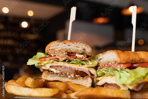 Foto sándwich de milanesa con lechuga tomate jamón y queso